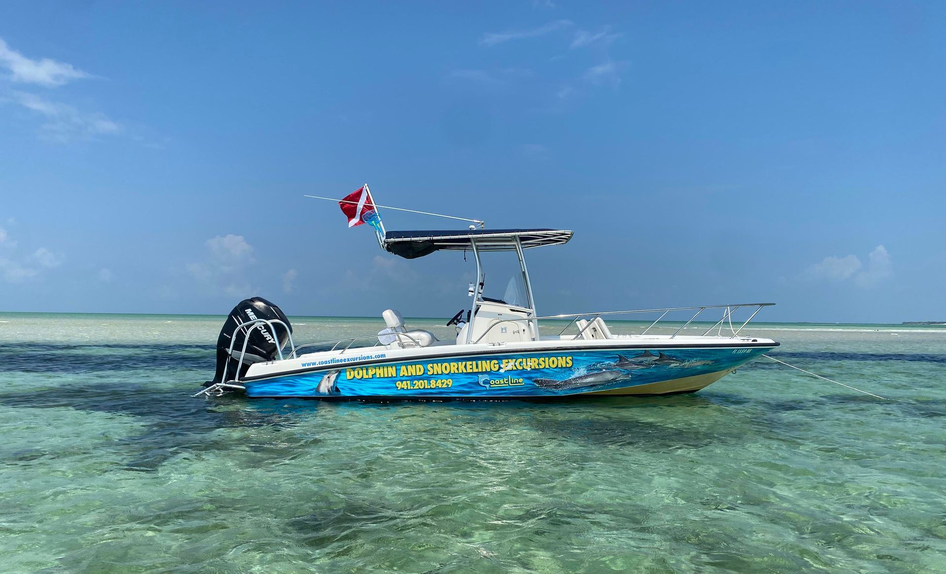 A blue and white boat is floating on top of a body of water.