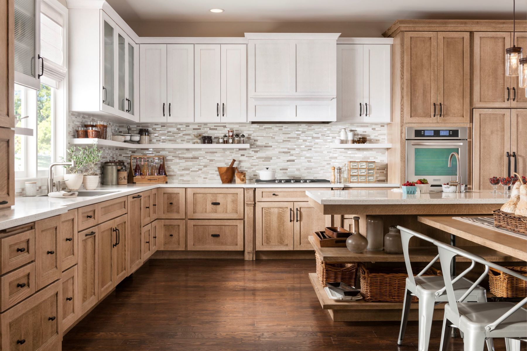 A kitchen with wooden cabinets and white cabinets and a large island.