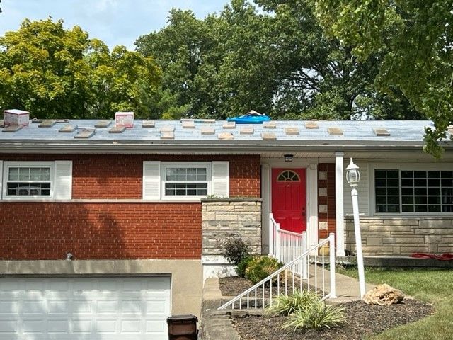 A red brick house with a white garage door and a red door.