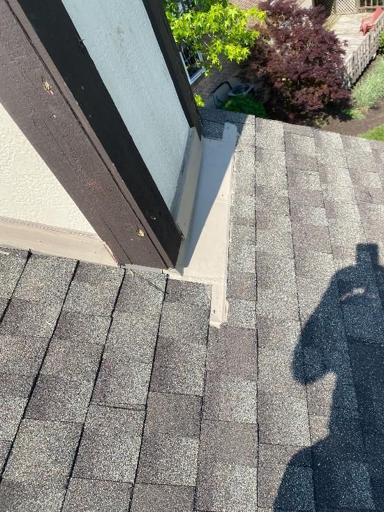 A close up of a roof with a shadow of a person on it.