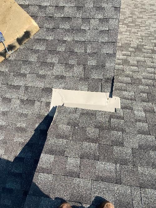 A person is standing on top of a roof with a hole in it.