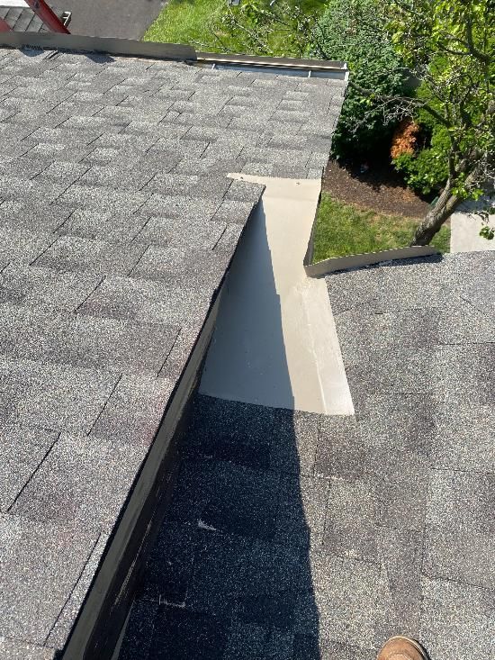 A person is standing on the roof of a house.