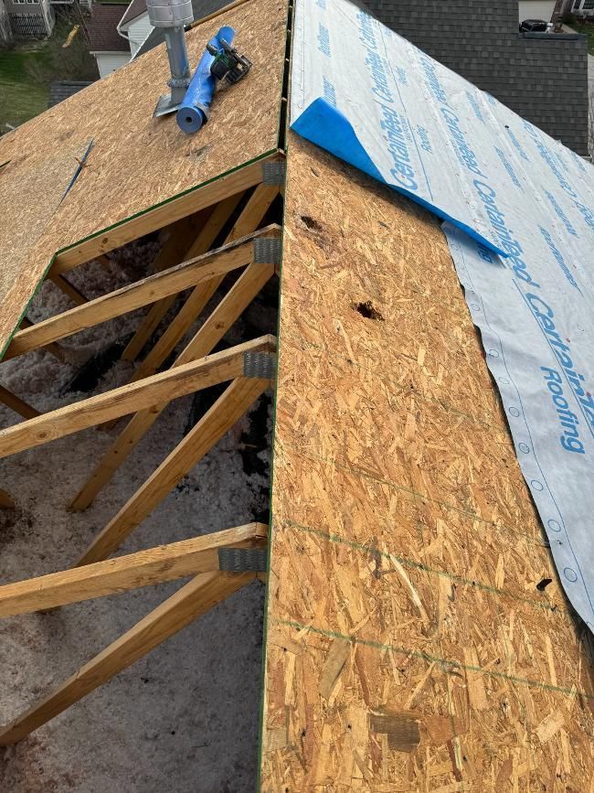 A roof is being built with wooden beams and plywood.