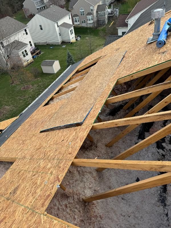 A man is working on the roof of a house.