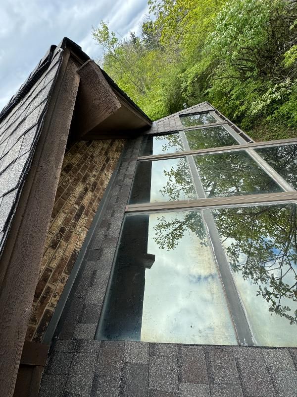 A roof with a lot of windows and trees in the background.