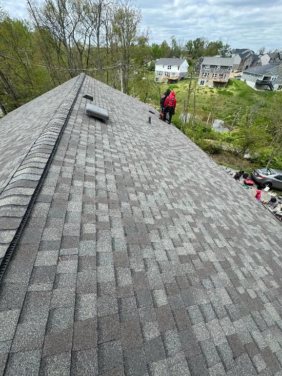 A man is standing on the roof of a house.