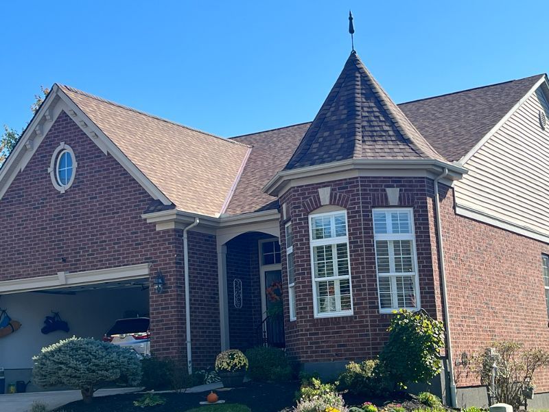 A large brick house with a roof that looks like a castle.
