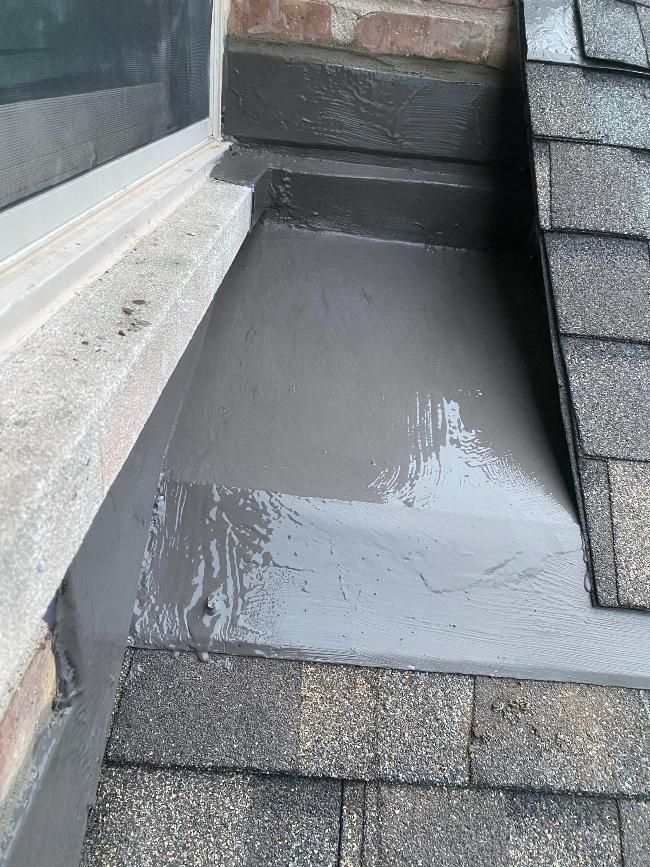 A roof with a window sill and a drain on it.