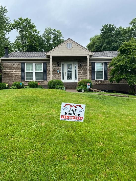 A brick house with a sign in front of it.
