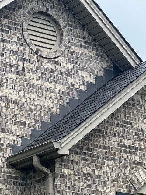 A brick building with a roof and stairs