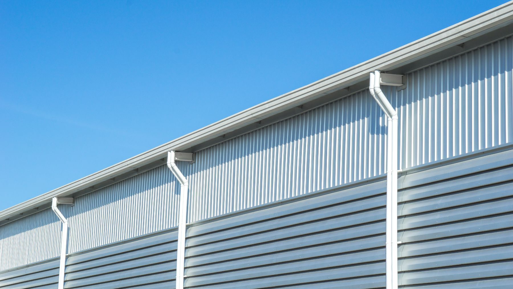 A large metal building with a blue sky in the background.