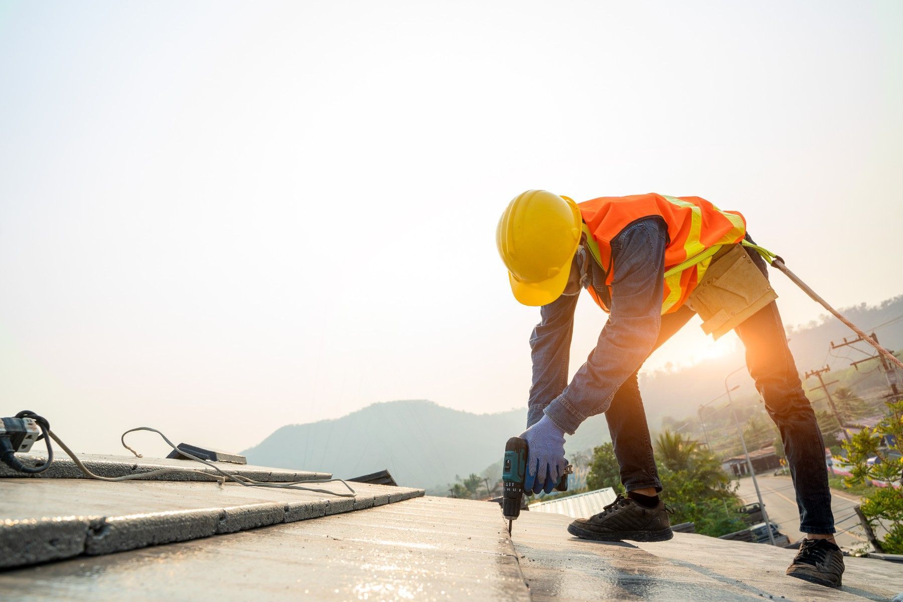 A construction worker is using a drill on a concrete surface.