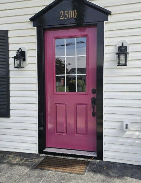 Pink front door with windows and house number 2500, flanked by black wall lanterns