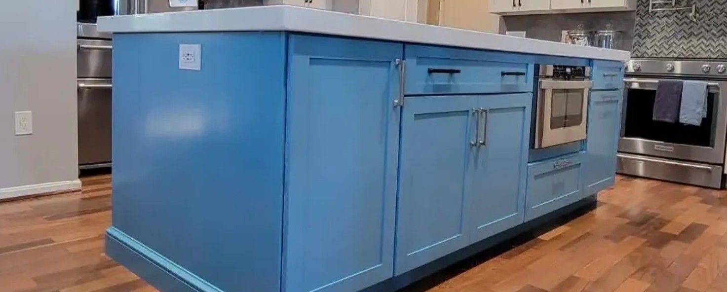 Blue kitchen island with built-in oven on a hardwood floor in a modern kitchen
