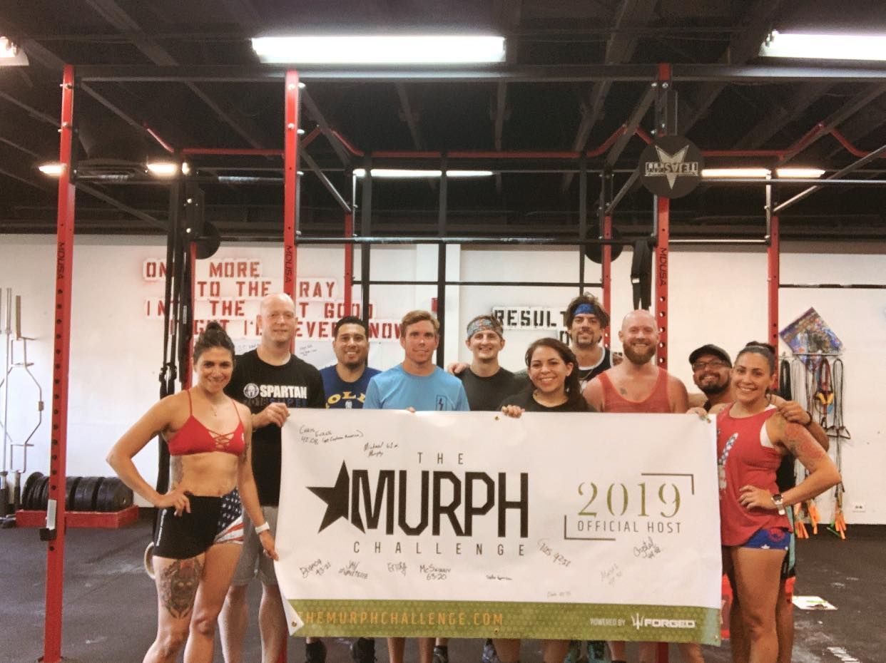 A group of people are posing for a picture with a banner that says murph 2019