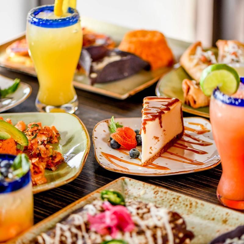 A table topped with plates of food and drinks.