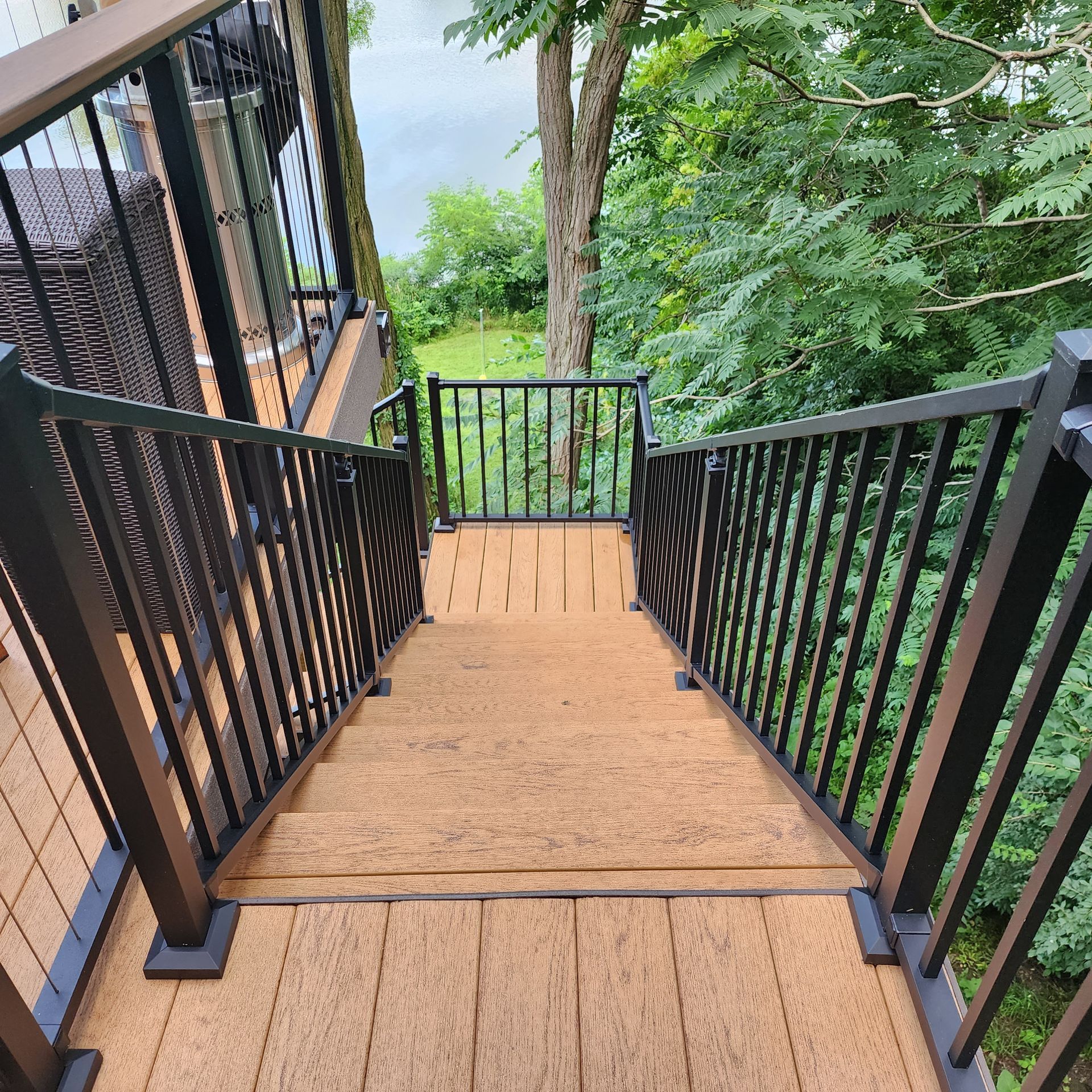A set of stairs leads up to a wooden deck with a metal railing