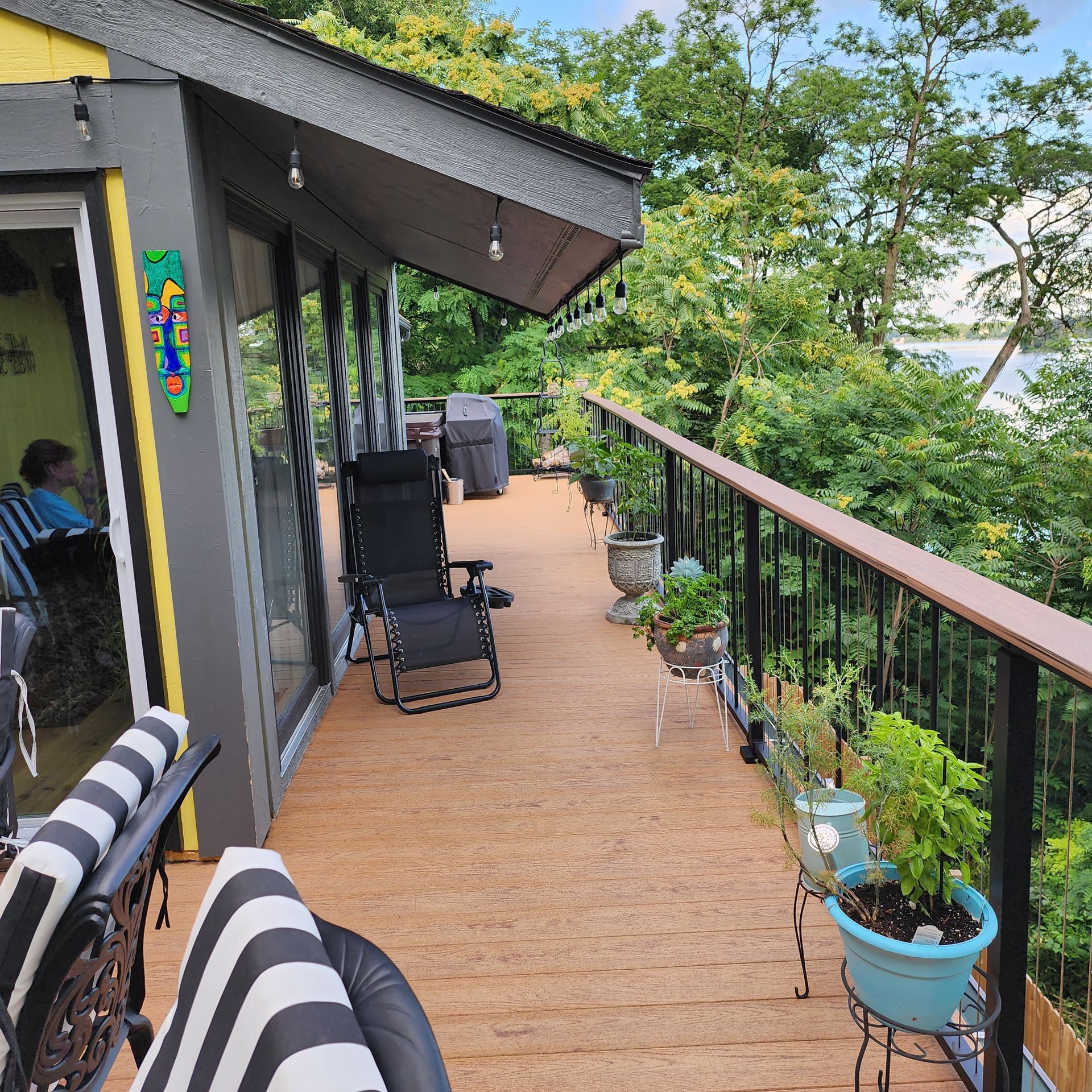 A deck with chairs and potted plants