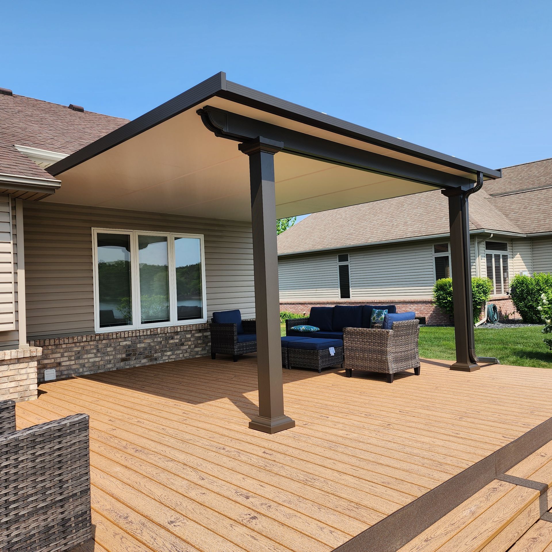 A covered deck with a couch and chairs