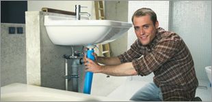 Friendly plumber fixing a sink