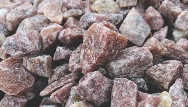 Pile of rough pink and gray rocks or gravel filling the frame