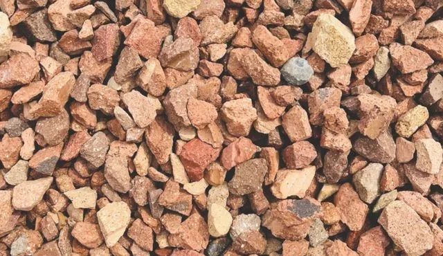 Close-up of mixed tan, red, and gray gravel stones filling the frame