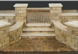 Stone steps and curved brick walls leading to a raised walkway with brick paving and pillars.