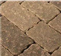 Close-up of weathered tan cobblestone pavement with irregular brick pattern