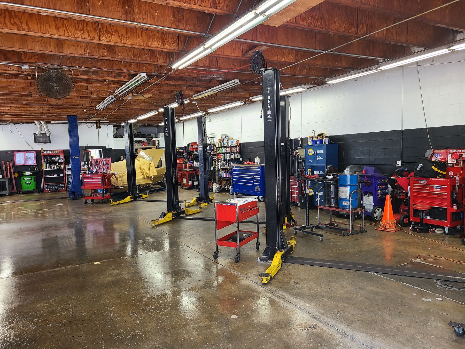 A large garage with a lot of tools and lifts.