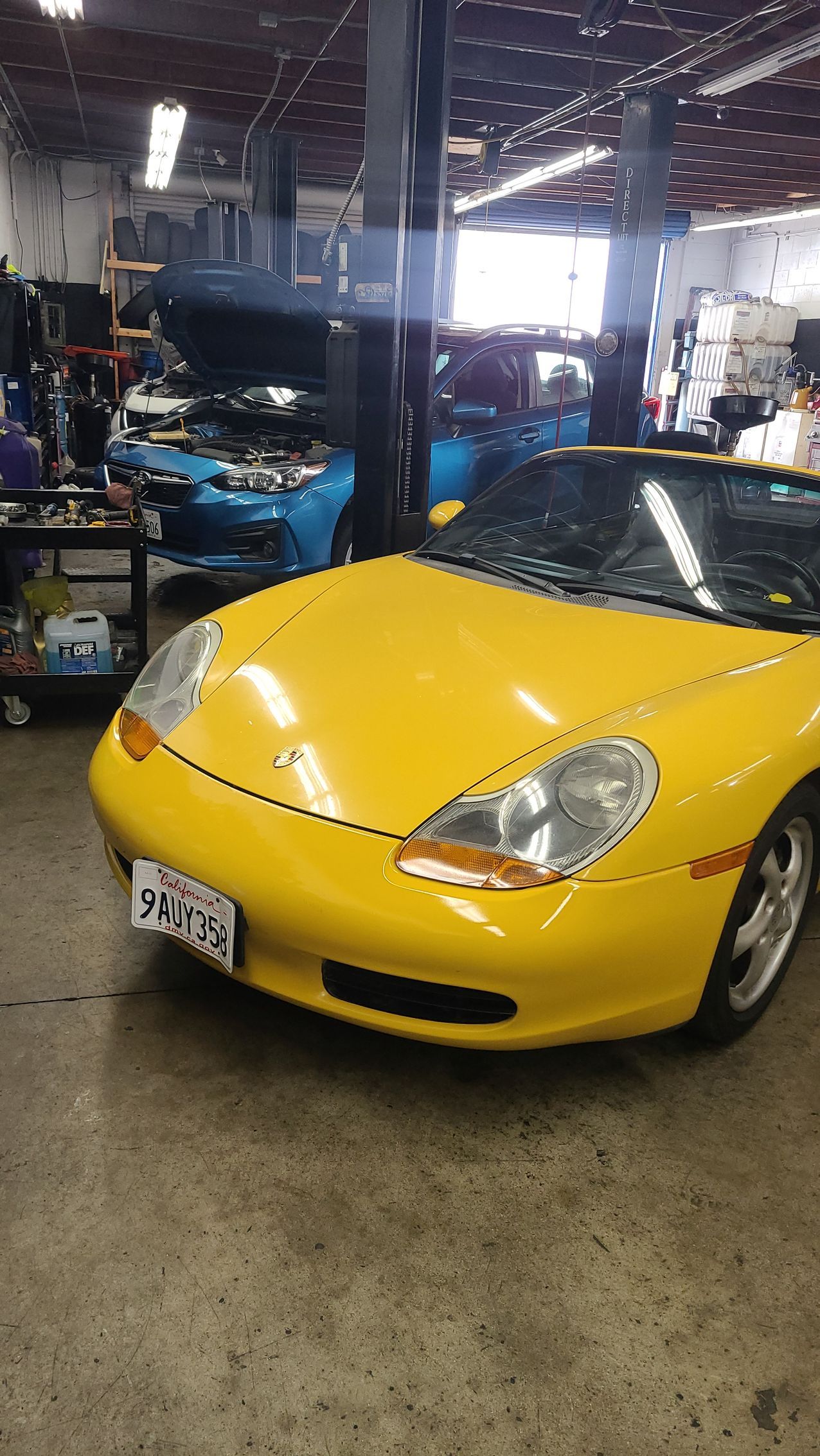 A yellow sports car is parked in a garage.