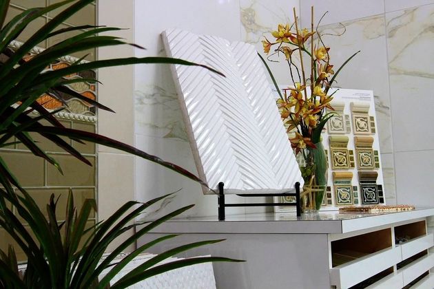 Modern console table with mirror, floral arrangement, and decorative wall blocks in a bright room