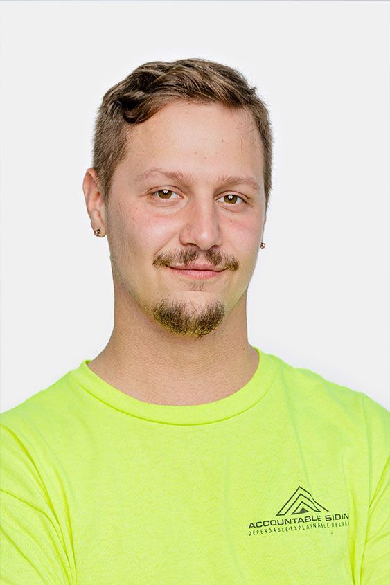 A man with a beard is wearing a neon yellow shirt.