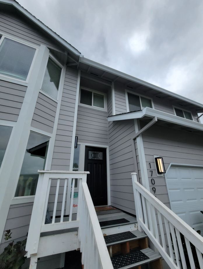 A large house with stairs leading up to the front door.