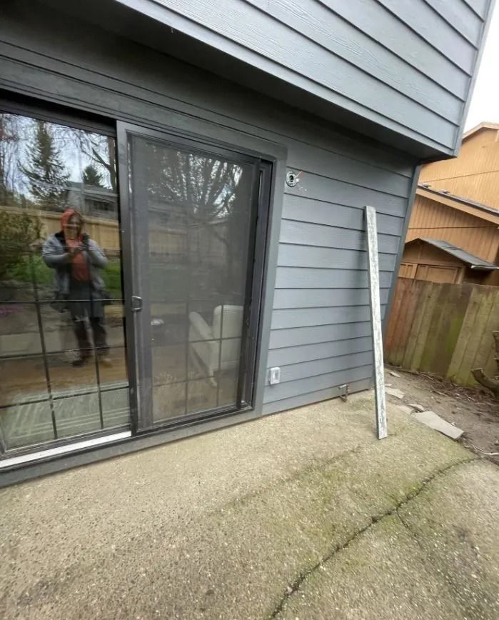 A man is standing in front of a sliding glass door.