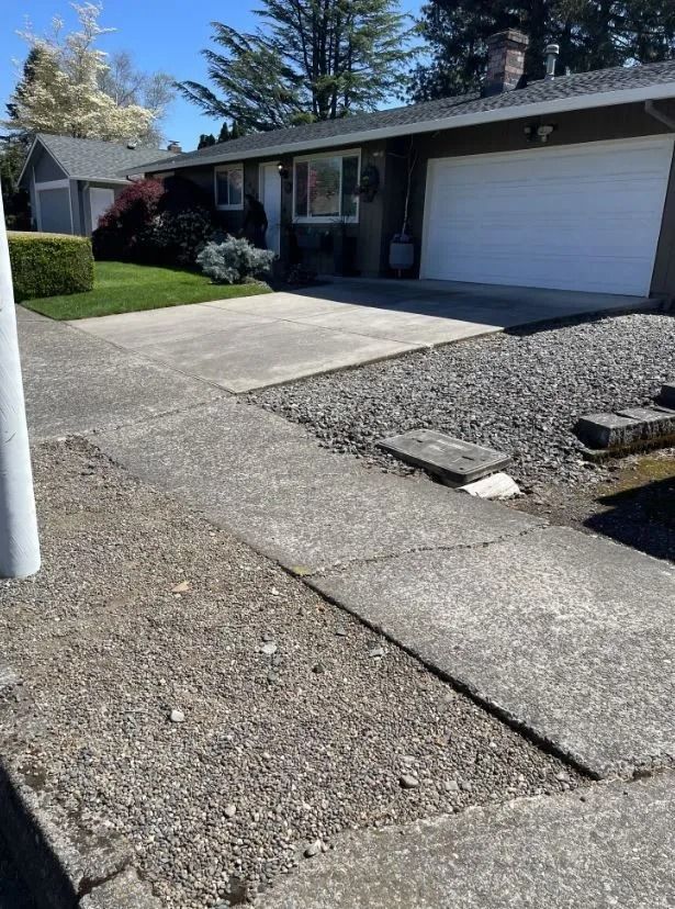 A house with a garage and a sidewalk in front of it.