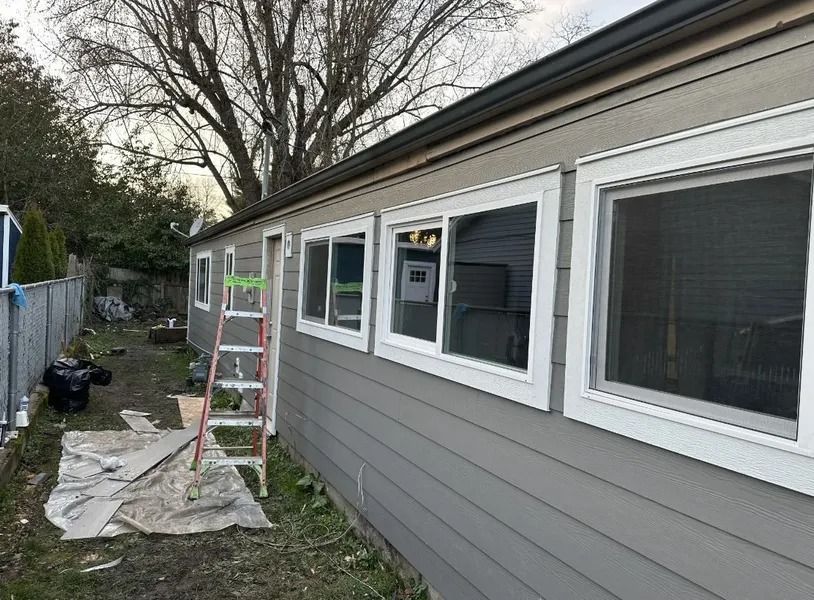 A house with a lot of windows is being painted.