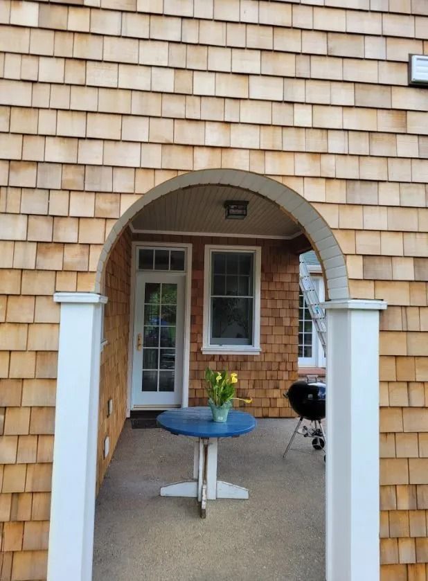 A porch with a table and a grill on it