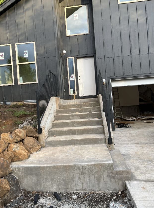 A black house with stairs leading up to the front door