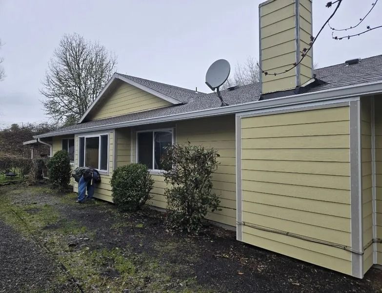 A yellow house with a satellite dish on the roof