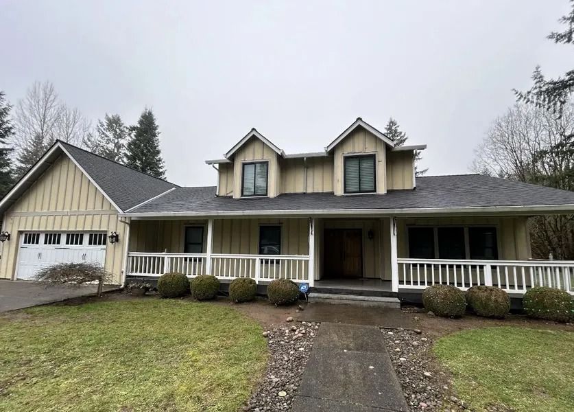 A large house with a porch and a garage