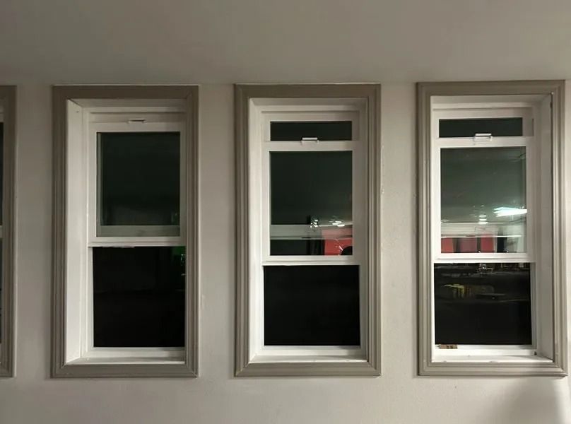Three windows are lined up on a white wall.