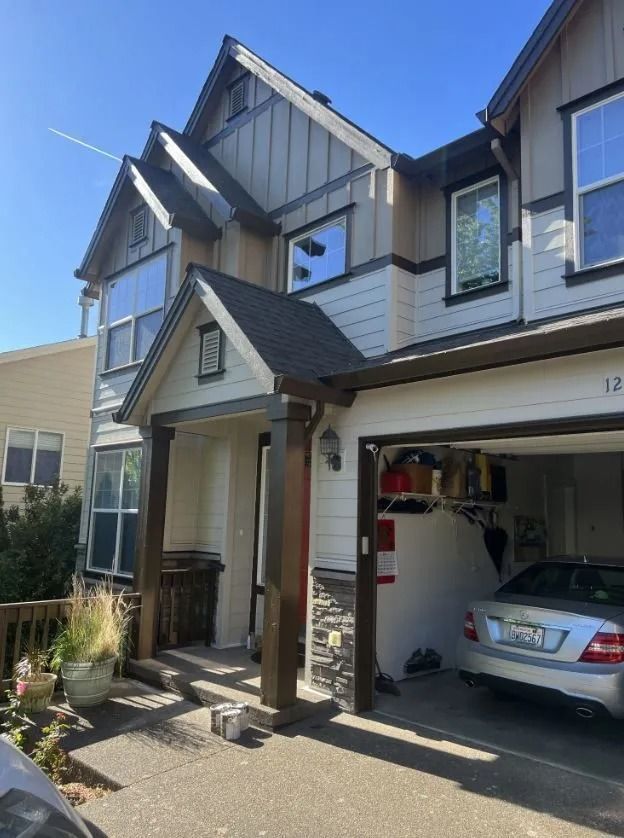 A car is parked in front of a house with the number 12 on it