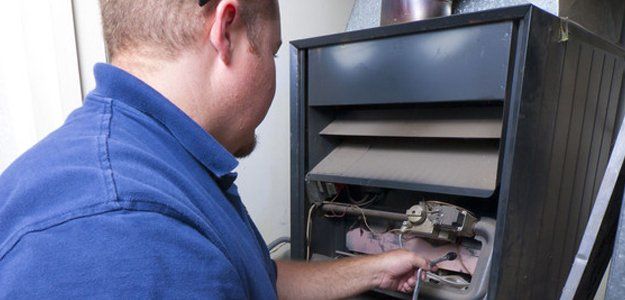 Heater Repair Man testing indoor furnace