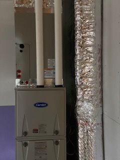 Carrier furnace with vertical pipes and insulated ductwork in a utility room