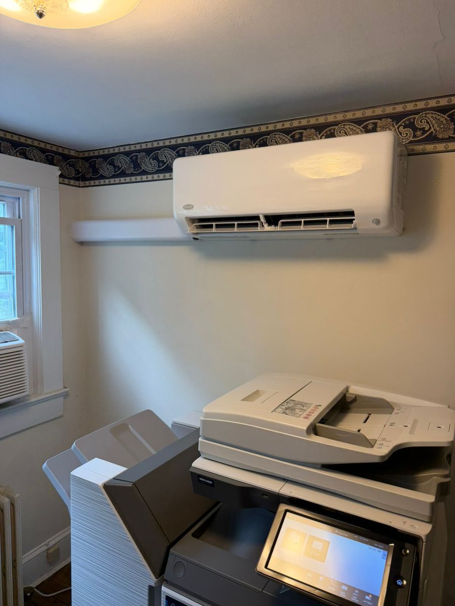 Small office with printer/copier, window AC, and wall-mounted mini-split air conditioner.