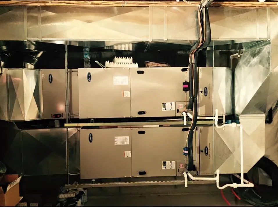 Industrial HVAC units and ductwork in a metallic mechanical room