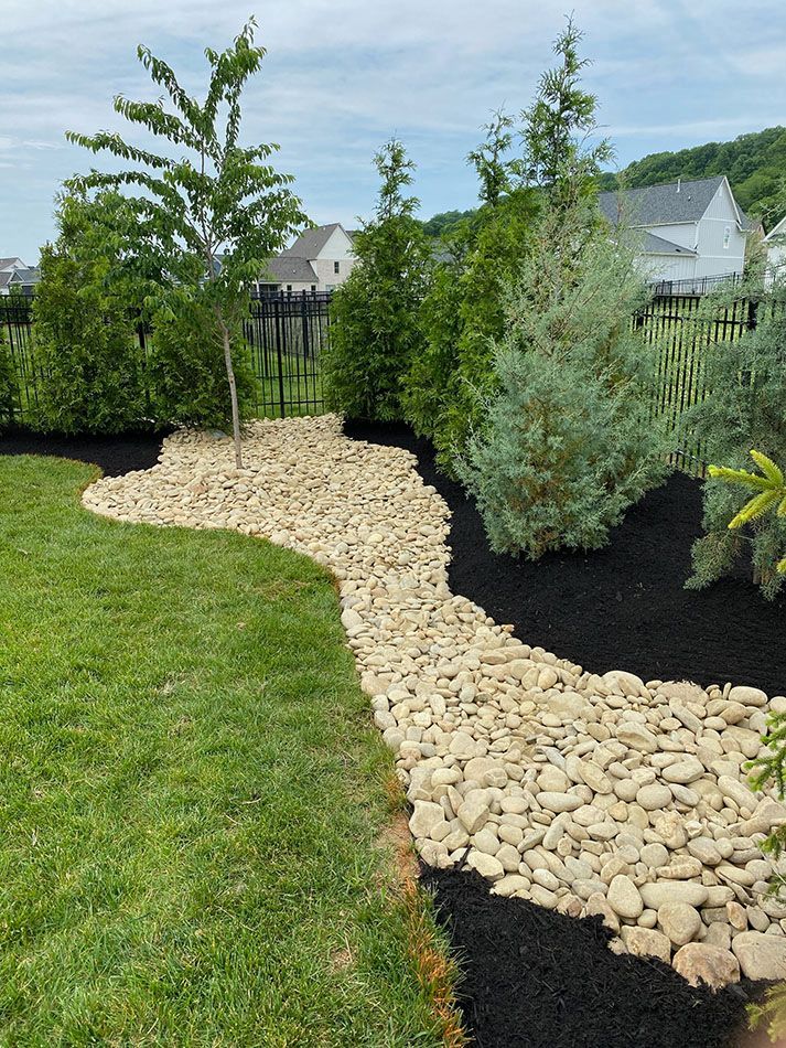 A garden with a path made of rocks and mulch.