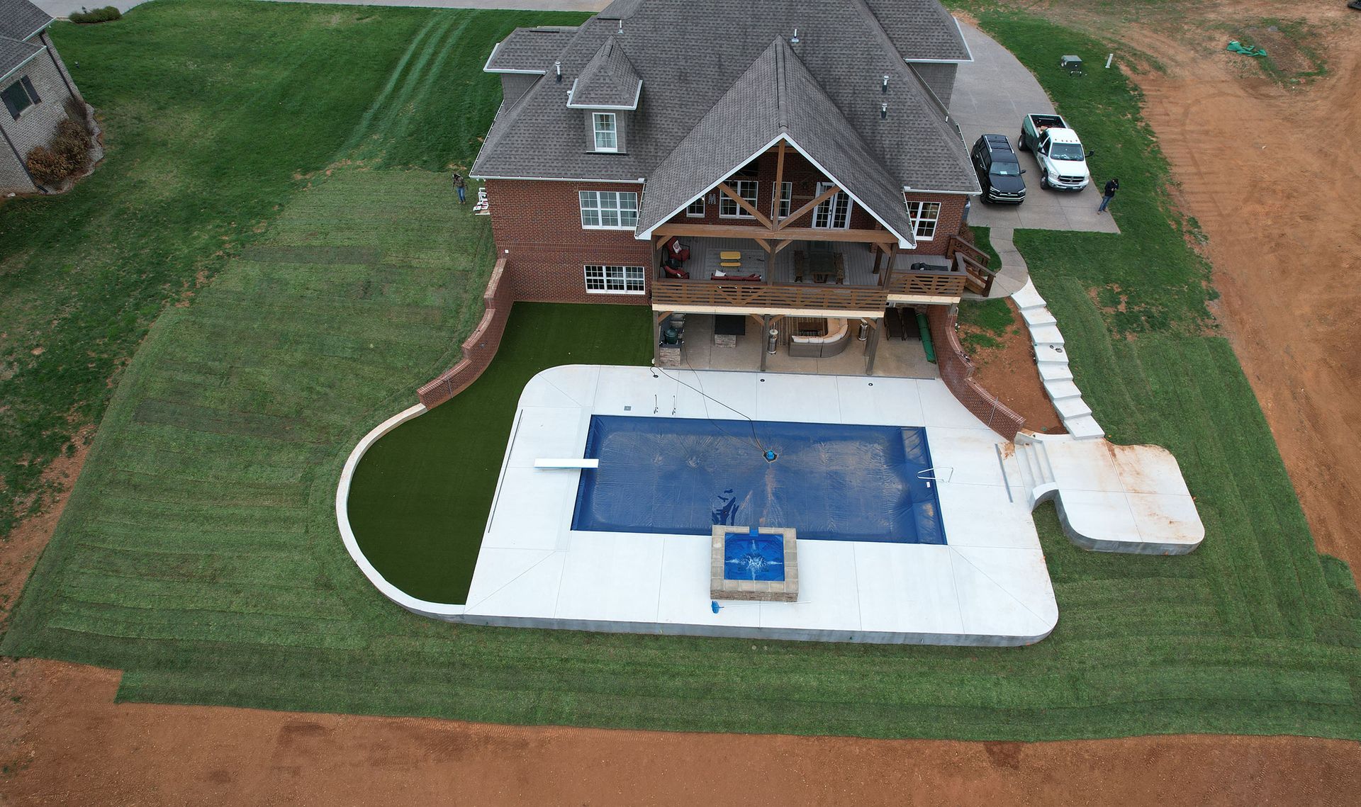 An aerial view of a house with a large swimming pool.