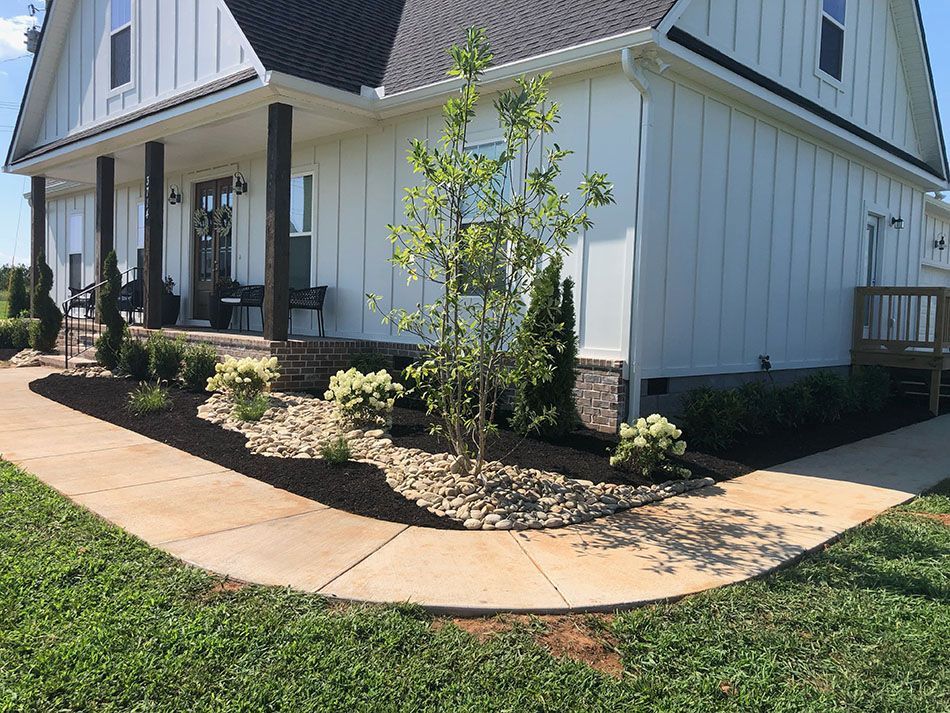 A white house with a porch and a walkway leading to it.