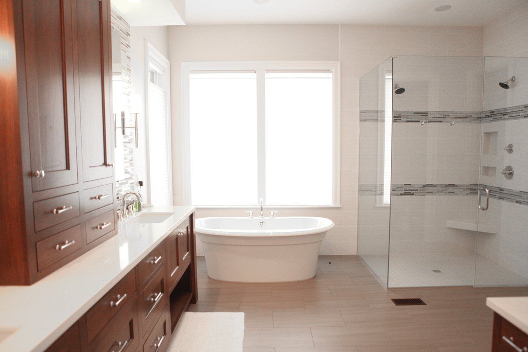 Bright bathroom with double vanity, freestanding tub, and glass walk-in shower